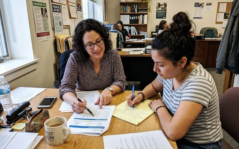 A person sitting across from a credit counselor reviewing a budget worksheet during a free consultation